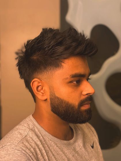 A textured haircut with a low fade and a sharp beard lineup. This style has great movement and a clean finish.
