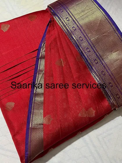 A red saree with a blue and gold border, a classic combination.