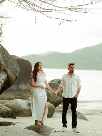 A stylish portrait on a rocky beach in Goa. The couple's pose against the natural rock formations and the sea creates a beautiful and dramatic pre-wedding image.