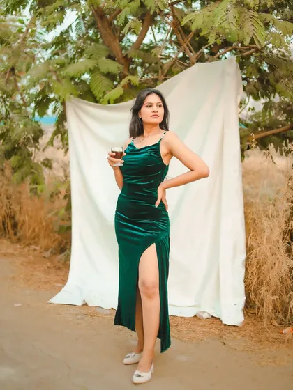 Another shot with the green velvet dress, this time holding a glass. It adds a touch of glamour and storytelling to the outdoor shoot.