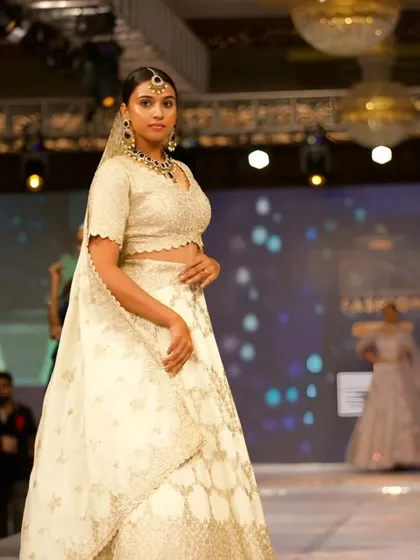 A model on the runway wearing one of my Kundan sets with a beautiful white lehenga. This shows how versatile my pieces are for high-fashion looks.