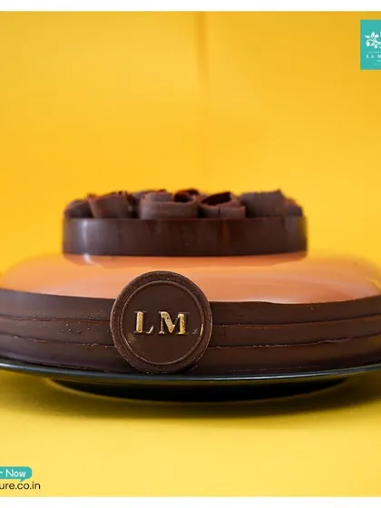 A side profile of the Chocolate Orange mirror glaze cake, showing the clean lines and the detailed chocolate work that encircles the base and top.