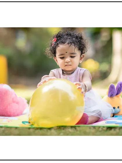 A playful shot of a toddler interacting with a balloon during her outdoor session. Using simple props can lead to wonderful, candid moments.