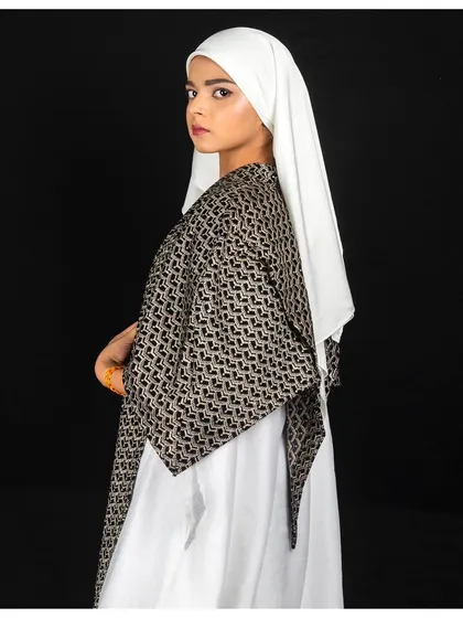 A profile shot that offers a different perspective on the outfit. This angle highlights the structure of the garment and the elegant way the hijab is styled, adding variety to the series.