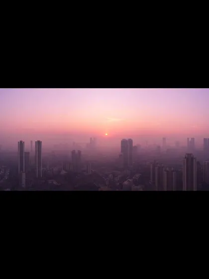 A panoramic shot of a purple-hued winter sunset over Mumbai, with the city's skyline partially obscured by a thick haze.