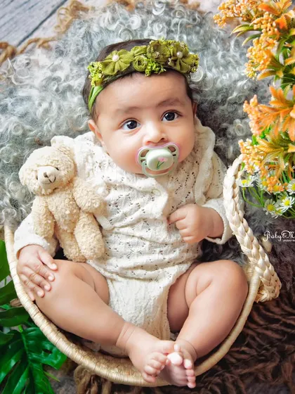 This little beauty is wide awake and taking it all in. The green floral headband and natural textures create a lovely, earthy vibe for her portrait.