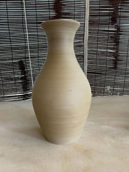 A collection of large, unglazed vases in various shapes and sizes. Each one is thrown on the wheel and showcases a different form, from classic curves to textured surfaces.