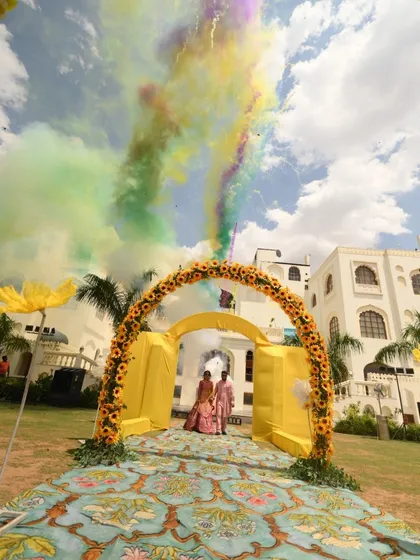 The couple's grand entrance for their Haldi ceremony, marked by a burst of colorful smoke against the sky.