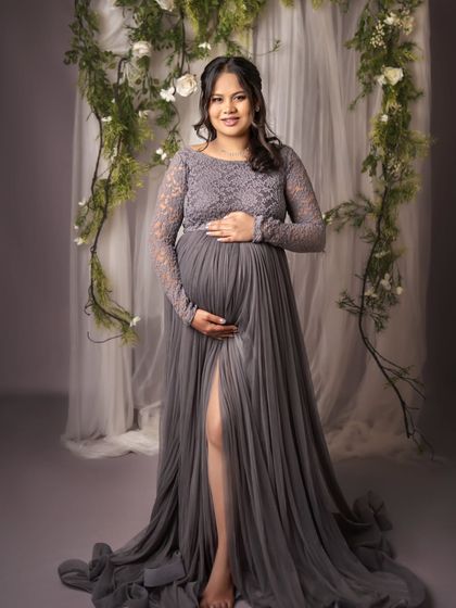 This mom-to-be looks so confident and radiant. The elegant grey gown and the soft lighting perfectly highlight her beautiful pregnancy silhouette.