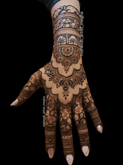 A stunning back-hand design against a dark background, highlighting the intricate floral and architectural details that flow from the wrist to the fingers.