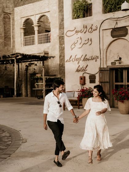 A happy, walking shot of the couple exploring the Al Seef Heritage Hotel area in Dubai.