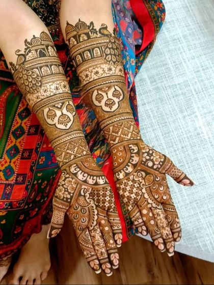 This design is packed with traditional elements, including jharokhas, peacocks, and auspicious symbols, perfect for a traditional bride.