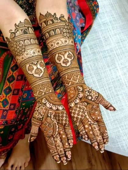 This design is packed with traditional elements, including jharokhas, peacocks, and auspicious symbols, perfect for a traditional bride.