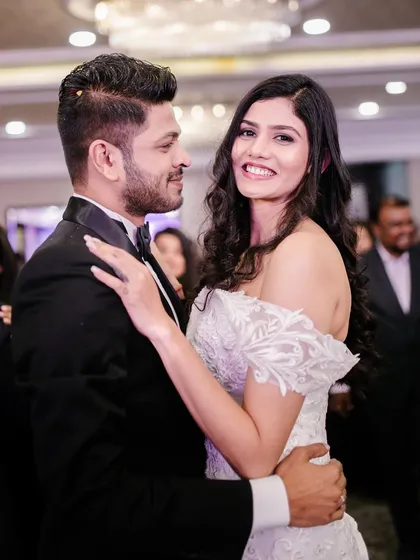 A romantic moment between the couple. The bride's smokey eye makeup looks elegant and sophisticated, perfect for her off-shoulder lace gown.