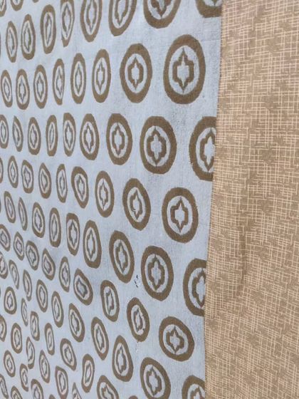 A close-up of an old tapestry restored into a quilt, showing the preserved pattern and new quilting.