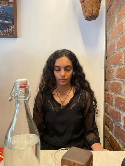 A candid shot of me in a cafe, with my eyes closed in a moment of inner stillness. It shows that mindfulness can be practiced anywhere, even in the midst of daily life.