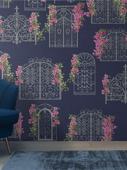 A mock-up showing the navy bougainvillea wallpaper in a living room setting with a blue armchair.