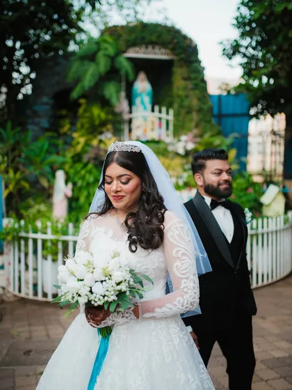 A candid shot of the bride looking down at her bouquet, with the groom looking on. This captures a natural, unposed moment.