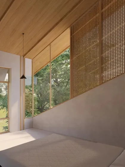 The bedroom in the Cumin Residence features a clean, minimalist aesthetic with an angled window and a woven screen, allowing for filtered light and views of the surrounding greenery.