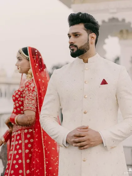 A portrait of the groom. Standing proud in his bespoke ivory sherwani, our client embodies the quiet confidence and regal charm that we strive to deliver with every garment.