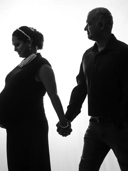 A classic black and white silhouette. The couple holds hands, their forms outlined beautifully against the bright background, creating a simple and powerful image.