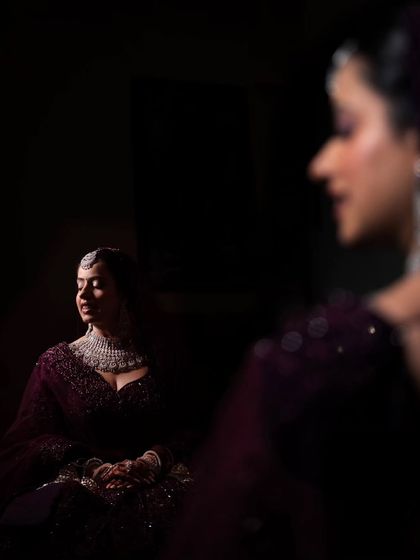 An artistic portrait of the bride, using reflections and shadows. This moody and sophisticated shot captures a moment of quiet contemplation.