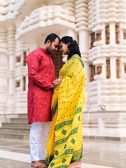 A quiet, forehead-to-forehead pose in front of the temple's intricate architecture. This shot emphasizes the couple's emotional connection and the sanctity of their journey into parenthood.