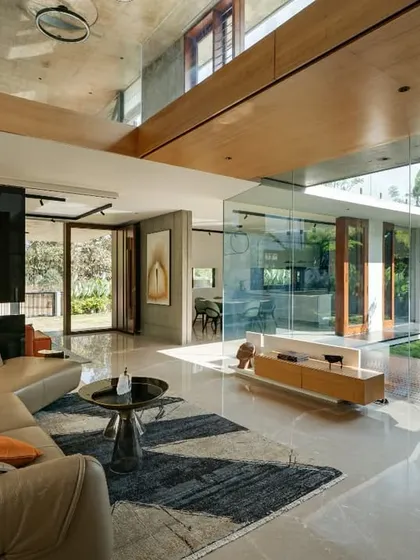 The living space of the Long House dissolves into the central courtyard through expansive glass walls. We designed this to create a seamless flow between the interior and the lush greenery, ensuring the home is filled with natural light and feels like an extension of the garden.