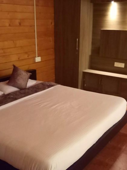 The cozy wooden interior of a bedroom in a Chikmagalur cottage, offering a warm and inviting atmosphere.
