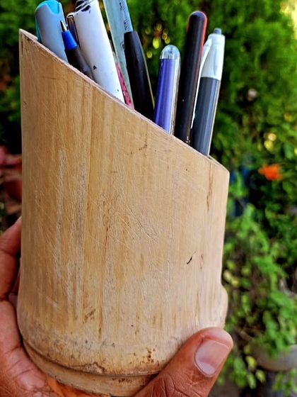 Organize your workspace sustainably with our stylish bamboo pen holder. This image, taken outdoors, emphasizes the natural origin of the product, making it a perfect blend of functionality and eco-friendliness.
