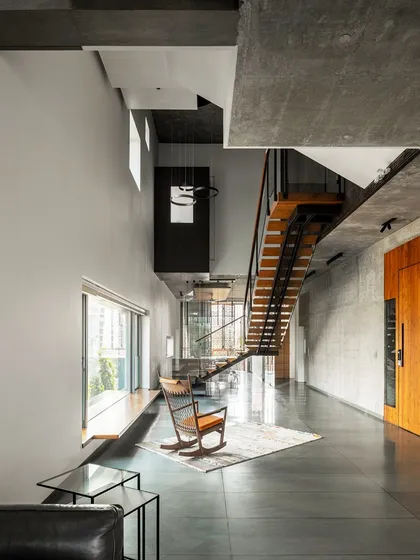 The double-height living space in J-House feels expansive and open, with a minimalist aesthetic that emphasizes the quality of light and the connection to the views outside.