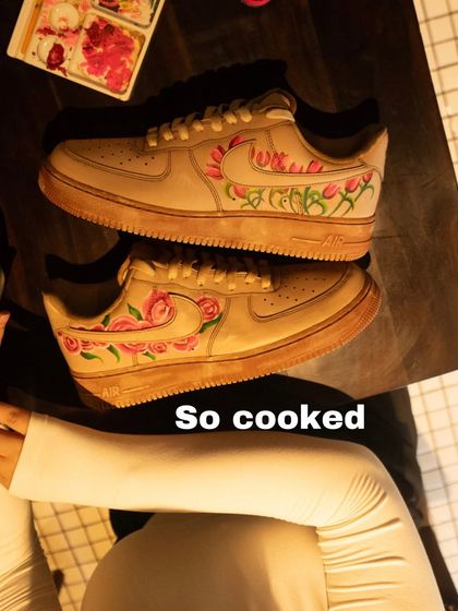 A top-down view of the floral Nike Air Force 1s after being coffee-dyed. The process gives the entire shoe, including the sole, a consistent and authentic vintage appearance.