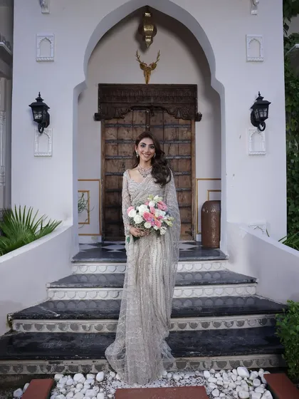 A smiling bride-to-be in her silver saree. This look is perfect for a modern engagement or reception.