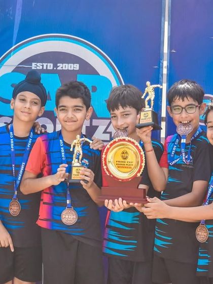 A young team proudly displays their medals and trophy. This is the reward for all their hard work and dedication.