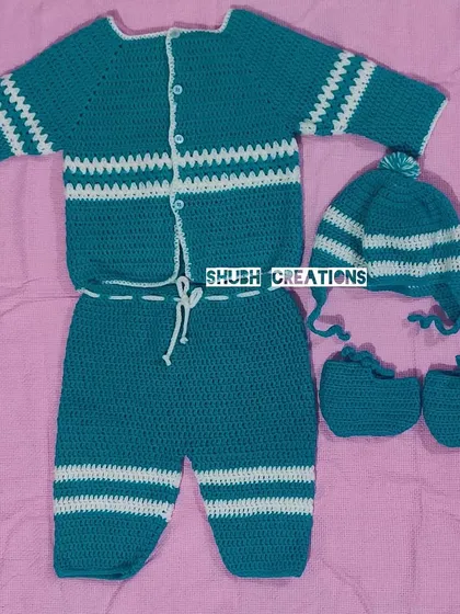 This complete hand-crocheted baby set, featuring a striped sweater, matching pants, a pom-pom hat, and tiny booties, is made with the softest yarn for your little one's comfort.