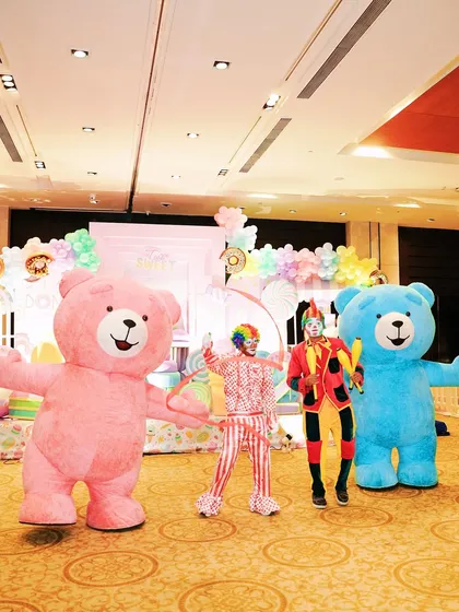 A lively entertainment lineup with two inflatable teddy bear mascots and clowns, ready to delight guests at a Candyland party.