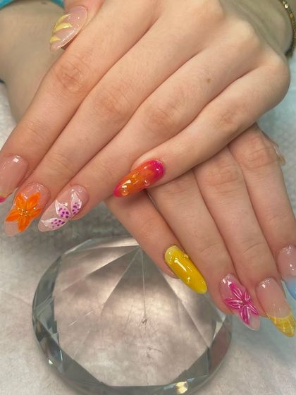 Summer shades on point. This vibrant and playful set features colorful tips, ombré effects, and intricate 3D acrylic flowers for a fun, textured look that's perfect for a vacation.