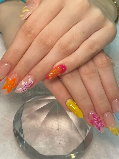 Summer shades on point. This vibrant and playful set features colorful tips, ombré effects, and intricate 3D acrylic flowers for a fun, textured look that's perfect for a vacation.