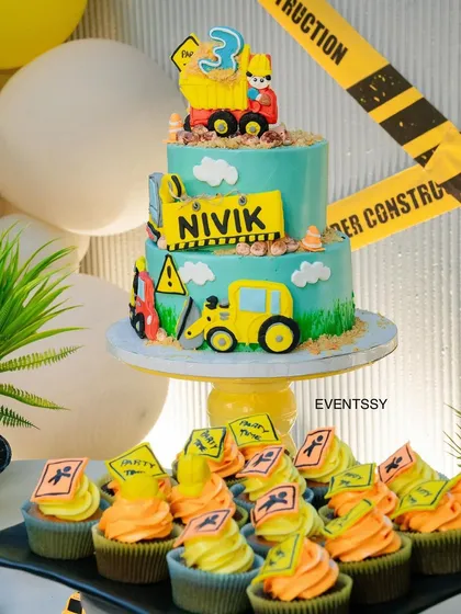 The construction-themed birthday cake and cupcakes, complete with edible trucks, signs, and caution tape.