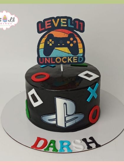 Level 11 unlocked! A sleek, black PlayStation-themed cake for Darsh's birthday, perfect for a dedicated gamer.