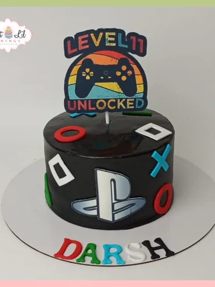 Level 11 unlocked! A sleek, black PlayStation-themed cake for Darsh's birthday, perfect for a dedicated gamer.