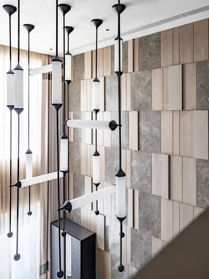 Lighting is everything. In this double-height dining space, we designed a cascading installation of statement lights that feels like a modern sculpture. It not only illuminates the room but also draws the eye upward, emphasizing the scale and grandeur of the architecture while creating an intimate dining atmosphere.