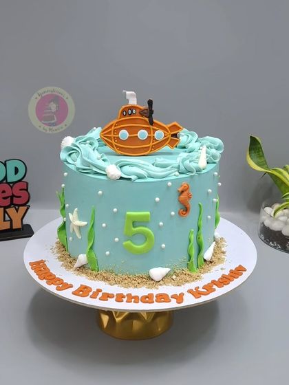 A cute underwater-themed cake with a submarine, seahorses, and starfish for Krishiv's 5th birthday.