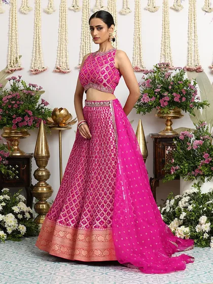 The side profile of our fuchsia Bandhani lehenga, showing how the dupatta can be draped to create a dramatic and elegant effect.