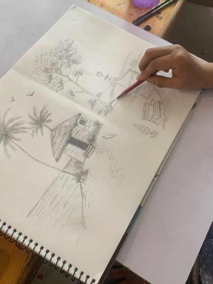 A student's sketchbook is open to a page filled with landscape compositions, showing the progress made during our sessions.