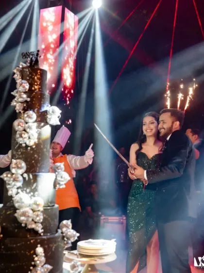 The cake cutting ceremony, but with a twist. Shruti and Divyansh use a sword to cut their magnificent, multi-tiered cake, a grand and memorable moment from their cocktail night.