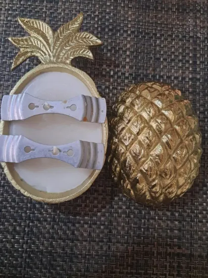 A look inside the pineapple-shaped urli candle, showing the placement of the two wooden wicks before the final pour.