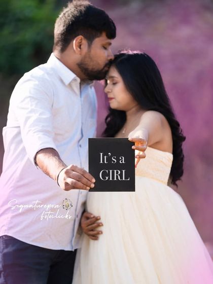 A sweet gender reveal moment for a baby girl, captured in an intimate outdoor setting with beautiful purple flowers.