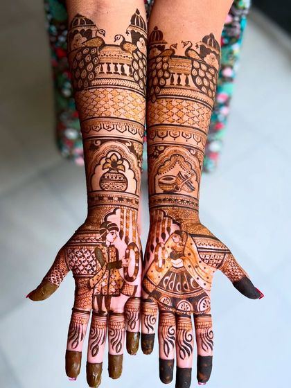 Another stunning addition to my Bridal Extravaganza package. This design features bride-groom figures, peacocks on the forearm, and traditional wedding pots (kalash), creating a classic and regal look.