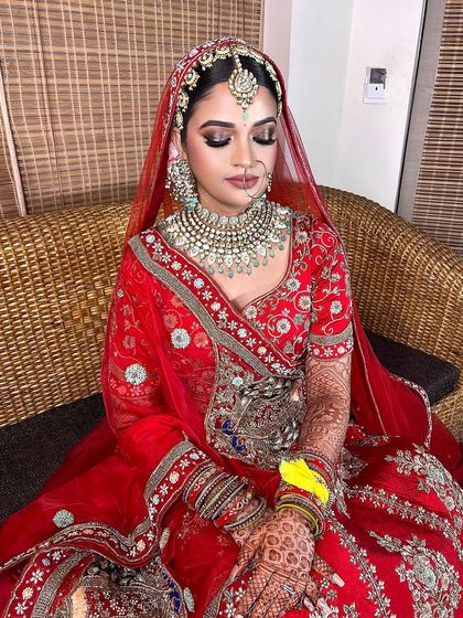 A full view of this gorgeous red bridal look. The makeup is designed to be long-wearing and photogenic, with a focus on enhancing the bride's features with a touch of shimmer and perfectly defined lips.